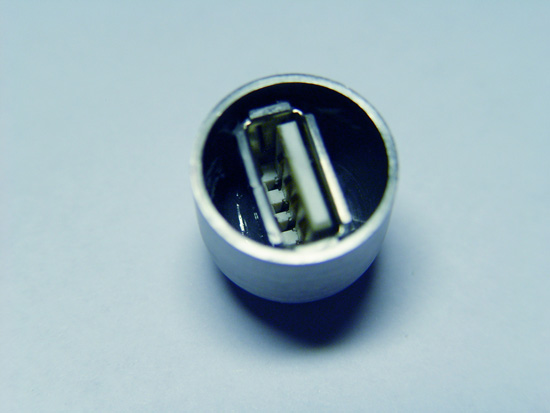 A female USB connector installed inside the metal cap