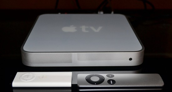 Общий вид ТВ-приставки Apple TV первого поколения с двумя вариантами пультов (старым и новым)